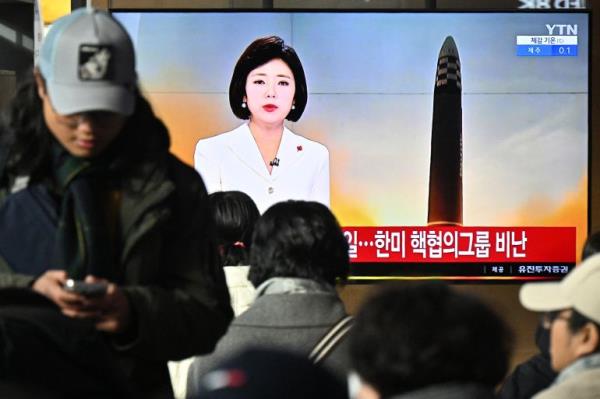 People watching a giant TV screen showing news a<em></em>bout the North Korean missile launch