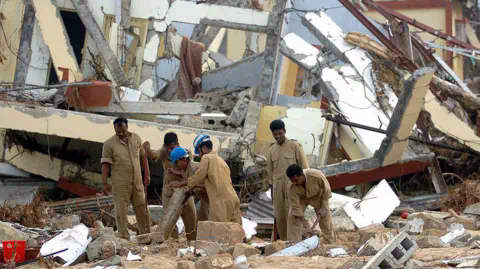 Getty Images MALACCA, INDIA: Indian airforce perso<em></em>nnel attempt to uncover docu<em></em>ments from a time record room in Malacca on Car Nicobar Island, 07 January 2005,which was totally destroyed by the tsunamis of 26 December 2004. Almost 1,200 people are listed as killed, with 5,600 missing on the Andamans archipelago. Some 44,000 survivors are housed in shelters on the Indian Ocean tropical chain of over 500 islands strung across 800 kilometres (500 miles) and located just east of Sumatra.