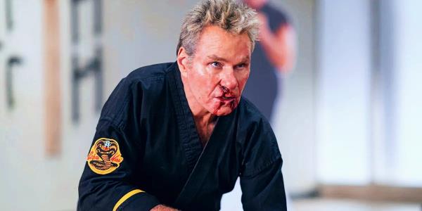 Martin Kove as John Kreese in Cobra Kai kneeling with blood on his face
